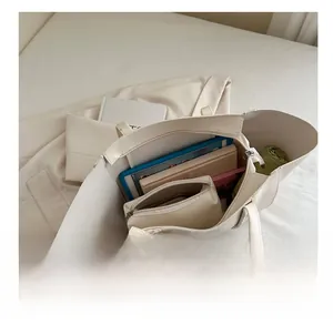 Spacious interior of beige tote bag showing tablet, books, and matching inner pouch