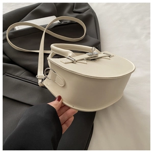 Détail du sac selle en cuir PU crème avec fermoir en métal argenté et poignée robuste