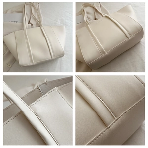 Detail shot of cream white PU leather tote bag with stitch textures and wing shape design