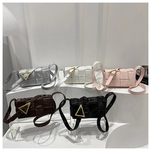 Detail showing five woven crossbody bags with golden triangle metal buckles and broad straps