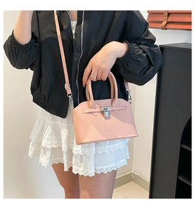 Dettaglio della borsa rosa in pelle con chiusura girevole argentata e tracolla