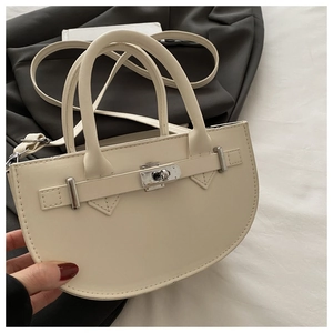 Détail du sac en similicuir crème avec boucle argentée et bandoulière amovible chic