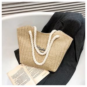 Close-up of straw tote bag with herringbone weave and thick cotton rope handles
