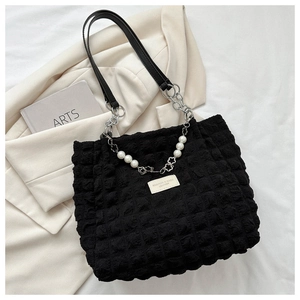 Detail of black bubble texture tote bag with pearl flower chain and leather strap