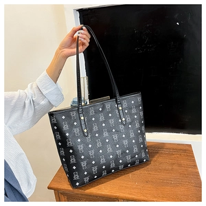 Detail shot of black tote bag featuring white bear prints and secure zipper closure