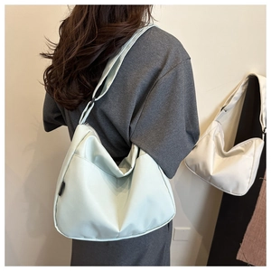Detail view of mint green nylon shoulder bag showing relaxed drape and minimalist design