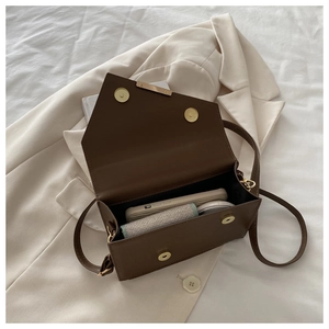Interior view of brown leather bag showing storage capacity for phone and cosmetics