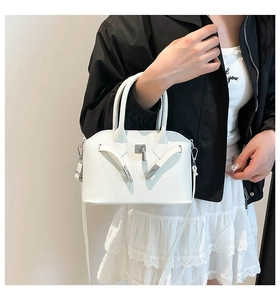 Detail van witte schelptas met lychee patroon en zilveren gesp en schouderriem