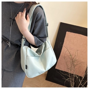 Detail of mint green waterproof nylon crossbody bag with adjustable wide strap and logo