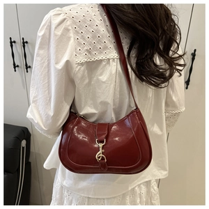 Vue détaillée du sac à bandoulière en similicuir bordeaux avec fermoir doré chic