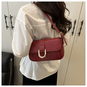 Close-up of wine red faux crocodile skin underarm bag with gold U-shaped metal buckle