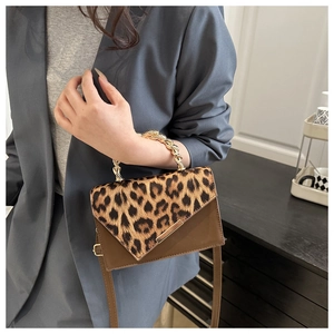 Close-up of leopard print panel and gold chain handle on a stylish crossbody bag