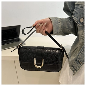 Close-up of black crocodile-embossed PU leather bag with U-shaped gold buckle detail