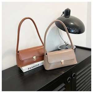 Detailed view of vintage baguette shoulder bags in brown and beige with gold metal buckles