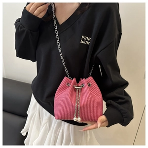 Detailansicht der rosa geflochtenen Eimertasche mit Silberkette und Perlen-Kordelzug
