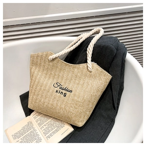 Detail of woven straw tote bag with cotton rope handles and Fashion embroidery