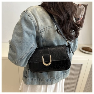 Detail of black crocodile pattern PU leather underarm bag with gold metal U-shaped buckle