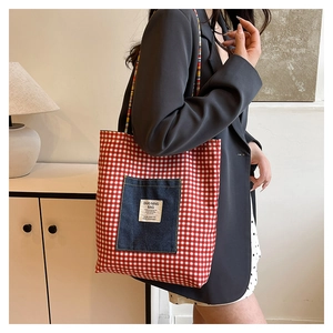 Détail du sac cabas en toile à carreaux rouge et blanc avec poche plaquée en jean