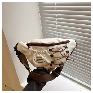Détail du sac bandoulière sport blanc avec sangles brunes et cordon élastique bungee