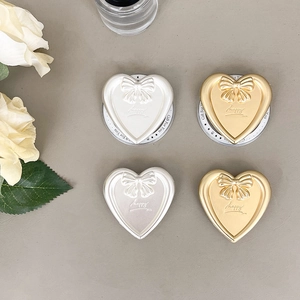 Macro view of heart and bow griptok phone stands in pearl white and gold finish