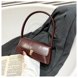 Detail of dark brown leather handbag with elegant gold square metal buckle and flap