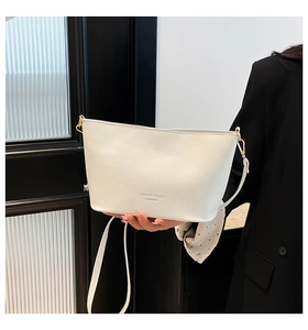 Détail du sac seau blanc à motif litchi avec foulard en soie et boucles dorées