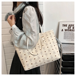 Macro shot of off-white tote bag with bear pattern and brown diamond grid detail