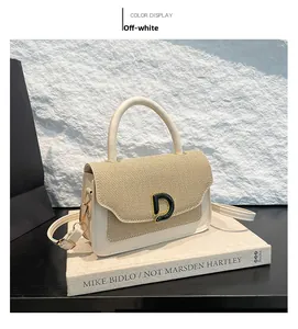 Dettaglio borsa a mano bianco crema con patta intrecciata e fibbia metallica a D