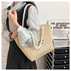 Straw tote bag with black fashion embroidery and cotton rope handles on female model