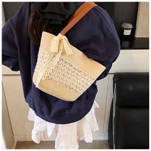 Detailed close-up of straw tote bag with delicate lace ribbon and vintage textures
