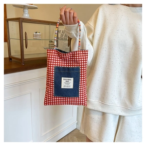 Détail du sac cabas vichy rouge avec poche en jean et anses en corde tressée colorée