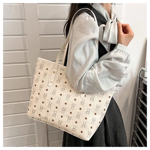 Detail view of large tote bag with cartoon bear pattern and reinforced rivets