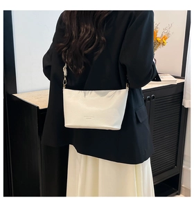 Détail d'un sac bandoulière blanc en cuir grainé litchi avec des crochets dorés