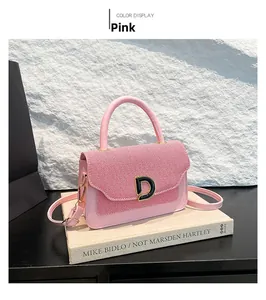 Dettaglio borsa rosa in pelle e tessuto a righe con logo D in metallo su libri vintage