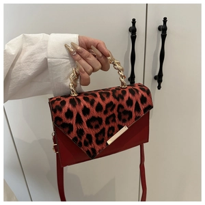 Detail of red leather contrast leopard print handbag with unique twisted gold metal handle