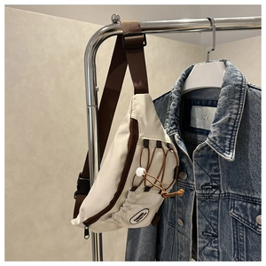 Détail du sac bandoulière crème avec cordon de serrage marron et sangle ajustable