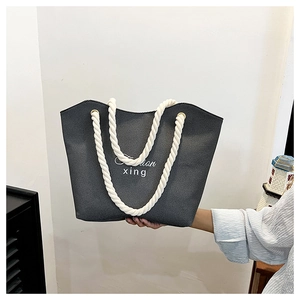 Detailed close-up of dark grey canvas tote bag with thick white cotton rope handles