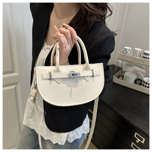 Détail d'un sac selle blanc avec boucle argentée et texture cuir sur la bandoulière réglable