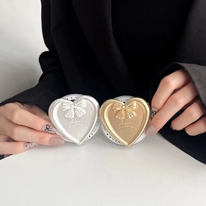 Macro detail of electroplated heart phone grip with bow relief and happy engraving