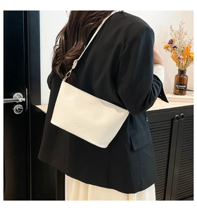 Détail du sac seau en cuir grainé blanc avec bandoulière réglable et gravure décorative