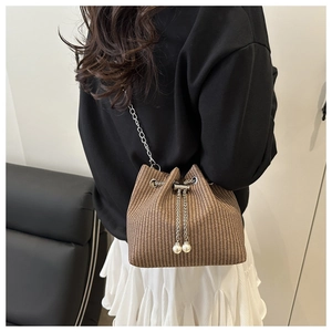 Détails du sac seau marron tressé avec bandoulière chaîne argentée et cordon à perles
