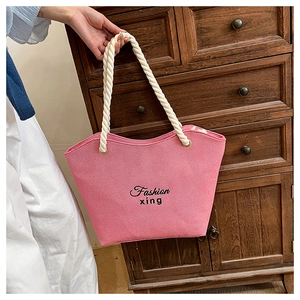 Pink canvas tote bag with black letter print and white braided rope handles detail