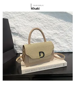 Dettaglio borsa patchwork kaki con fibbia a D dorata su sfondo di un libro