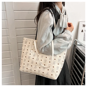 Side view of cream tote bag with bear pattern showing actual size on the shoulder
