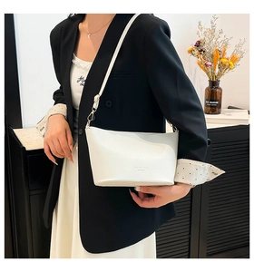 Détail du sac à bandoulière en cuir blanc avec motif litchi et boucle en métal doré