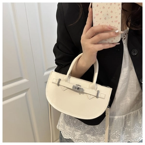 Détail du sac à main en cuir PU crème avec fermoir rotatif argenté et bandoulière