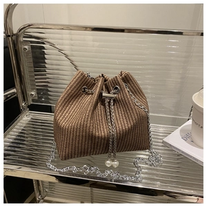 Détail du sac seau en pied-de-poule avec chaîne argentée et pendentif perle décoratif