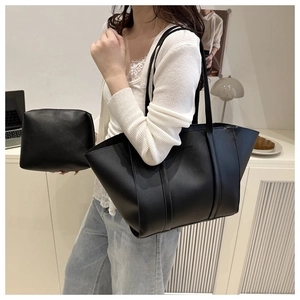 Close-up of black matte PU leather tote with 'FASHION' embossing and matching pouch
