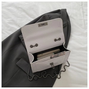 Internal view of white croc-embossed bag showing space for phone and small wallet