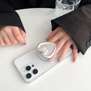 Detail of silver heart-shaped phone grip with bow relief and Gift For You text